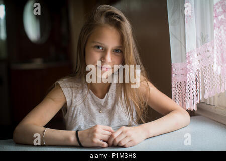 Portrait von niedlichen kleinen Mädchen am Tisch sitzen. Stockfoto