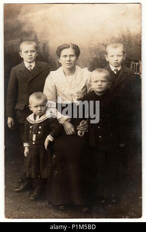 Deutschland - circa 1920s: Vintage Foto zeigt Mutter und ihre vier Söhne. Einer von ihnen trägt Sailor costum. Schwarz & Weiß antik Fotografie. Stockfoto