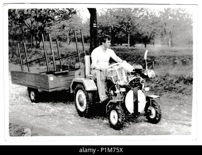 DIE TSCHECHOSLOWAKISCHE SOZIALISTISCHE REPUBLIK - 17. MAI 1984: Retro-Foto zeigt Landwirt fährt Kompakttraktor. Vintage Schwarz-Weiß-Fotografie. Stockfoto