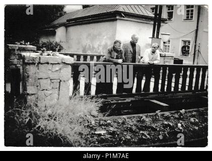Die tschechoslowakische SOZIALISTISCHE REPUBLIK - circa 1970 s: Retro Foto zeigt Männer stehen an der hölzernen Geländer (Geländer) außerhalb. Schwarz & Weiß vintage Fotografie. Stockfoto