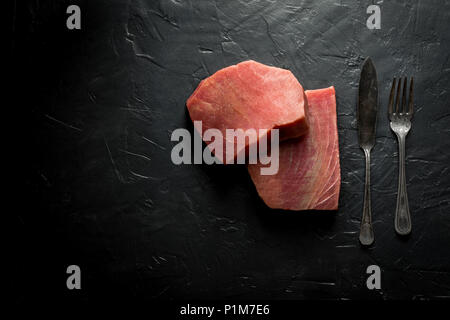 Rohen Thunfisch Steak auf dunklem Stein Hintergrund Stockfoto
