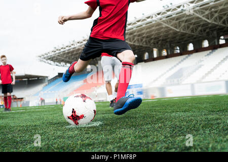 Nicht erkennbare Fußballspieler Kicking Kugel Stockfoto