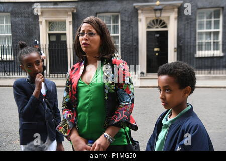 Lokaler Bewohner Judith Zacharias (Mitte) mit ihren Kindern Soliana und Alexander außerhalb 10 Downing Street in London, vor einem Grün für Grenfell Rezeption, bewirtet durch Premierminister Theresa May, mit Kindern durch den Brand betroffen. Stockfoto