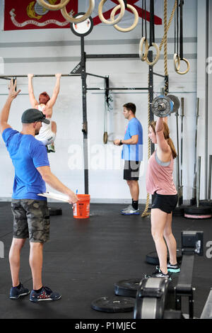 Weibliche oder Frau in einer CrossFit Fitness Challenge Wettbewerb durch tote Gewichte in einer Turnhalle in Montgomery Alabama, USA konkurrieren. Stockfoto