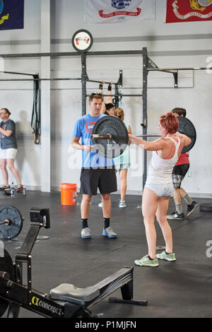 Weibliche oder Frau in einer CrossFit Fitness Challenge Wettbewerb durch tote Gewichte in einer Turnhalle in Montgomery Alabama, USA konkurrieren. Stockfoto