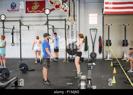 Weibliche oder Frau in einer CrossFit Fitness Challenge Wettbewerb durch tote Gewichte in einer Turnhalle in Montgomery Alabama, USA konkurrieren. Stockfoto