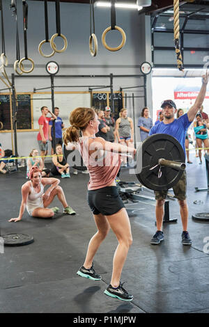 Weibliche oder Frau in einer CrossFit Fitness Challenge Wettbewerb durch tote Gewichte in einer Turnhalle in Montgomery Alabama, USA konkurrieren. Stockfoto