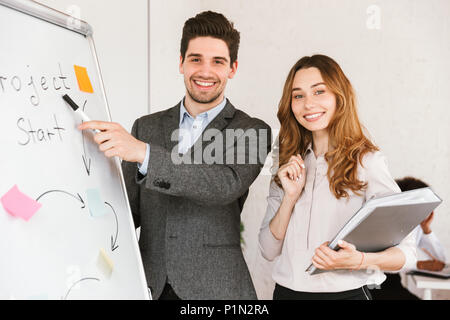 Lächelnden jungen Geschäft Paar präsentiert ein Projekt im Büro Stockfoto