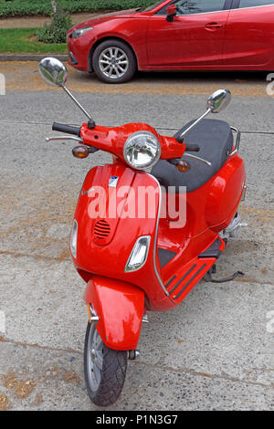 Red Vespa Motorroller in einer Wohnstraße, Vancouver, BC, Kanada geparkt Stockfoto