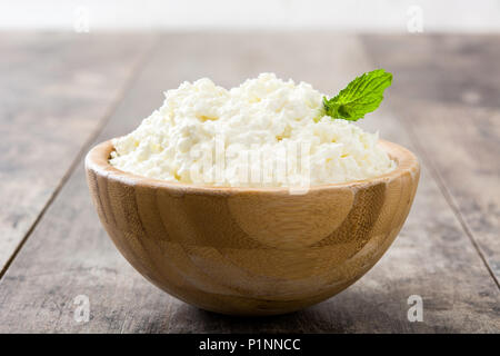 Frischer Quark in eine hölzerne Schüssel auf hölzernen Tisch Stockfoto