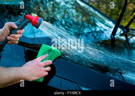 Closeup Bild, Bild junge Frau, Treiber, ihr Auto trocken wischen mit Mikrofasertuch nach dem Waschen, Reinigung Auto, Automobil Windows. Transportati Stockfoto