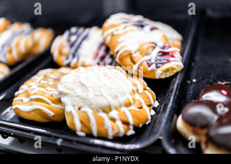 Nahaufnahme von vielen gelben Frischkäse Beerenfrucht Glasur beträufelt gebackenes Gebäck auf dem Regal Fach an Desserts in Bäckerei cafe Store Stockfoto