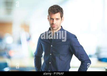 Portrait von hübscher junger Geschäftsmann Shirt tragen, während Sie im Büro stehen. Stockfoto