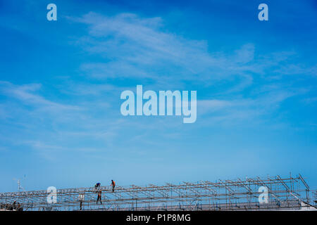 Bauarbeiter arbeiten auf Gerüsten. Blauen Himmel im Hintergrund Stockfoto