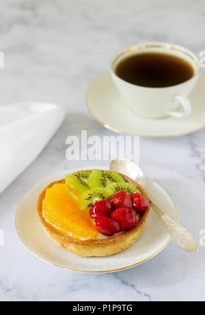 Mini Kuchen oder Torte mit Vanillesauce und verschiedene Früchte in Gelee. Selektive konzentrieren. Stockfoto