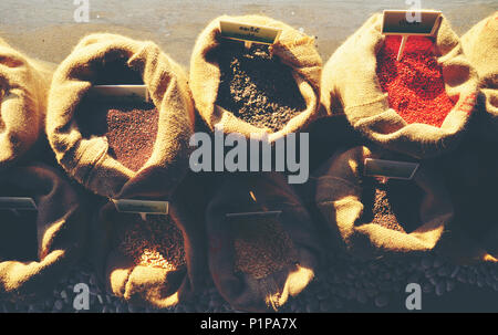 Samen von Senf, Flachs, Koriander und Sonnenblumen sind aus Leinen sacs verschüttet Stockfoto