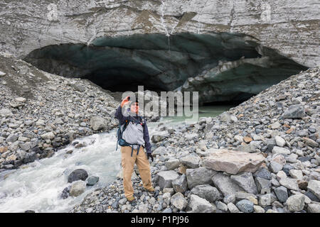 Männliche Wanderer nimmt ein Selbstporträt mit seinem Handy vor einem Gulkana Glacier Ice Cave, Alaska, Vereinigte Staaten von Amerika Stockfoto