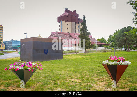 VUKOVAR, KROATIEN - 14. MAI 2018: Blick auf die Blumen in Schirme als Töpfe in einem Park mit dem Hotel Dunav im Hintergrund in Vukovar, Kroatien verwendet. Stockfoto