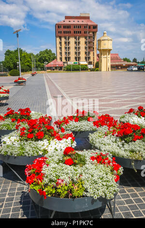 VUKOVAR, KROATIEN - 14. MAI 2018: Blumentöpfe auf der Promenade mit den verlassenen Hotel Dunav im Hintergrund in Vukovar, Kroatien. Stockfoto