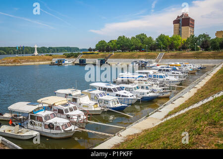 VUKOVAR, KROATIEN - 14. MAI 2018: Ein Blick auf die Boote an der Küste des Flusses Dunav mit dem Hotel Dunav und das Kreuz im Speicher des kroatischen Krieg günstig Stockfoto