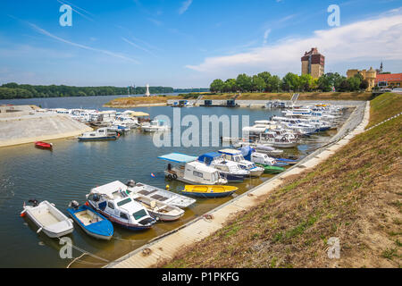 VUKOVAR, KROATIEN - 14. MAI 2018: Ein Blick auf die Boote an der Küste des Flusses Dunav mit dem Hotel Dunav und das Kreuz im Speicher des kroatischen Krieg günstig Stockfoto