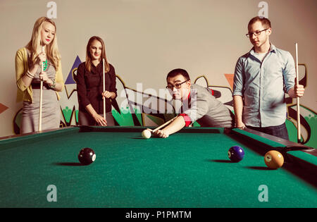 Eine Gruppe junger tausendjährigen Geschäftsleute ein Spiel der Pool auf einer Arbeit brechen; Sherwood Park, Alberta, Kanada Stockfoto