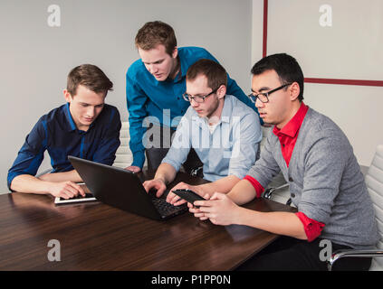 Junge Männer, die tausendjährige Geschäftsleute zusammen in einem Konferenzraum in einem High-Tech modernes Unternehmen arbeiten Stockfoto