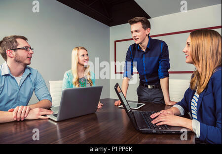 Junge tausendjährigen Geschäftsmann sprach mit einer Gruppe junger Fachleute in einem Konferenzraum in einem Geschäft; Sherwood Park, Alberta, Kanada Stockfoto