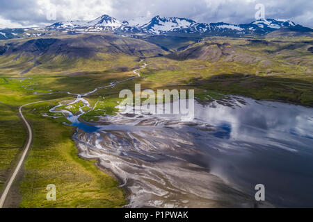 Die Straße Wicklung um Snaefellsness Halbinsel mit einer geflochtenen Fluss, der ins Meer läuft ; Island Stockfoto