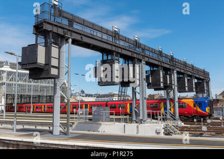 Eine S-Bahn S-Bahn betrieben durchdie South Western Railway verlassen Waterloo Station in London unter einer Marke neue verbesserte Signalisierung der Gantry. Stockfoto
