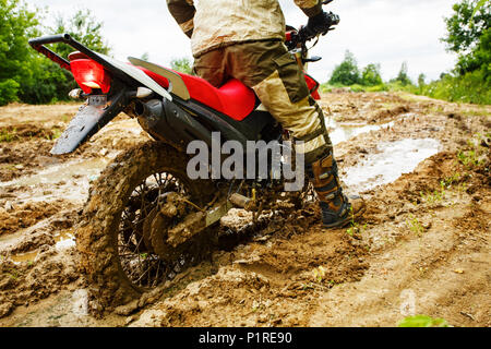 Der Mann auf dem Motorrad Fahrten durch den Schlamm Stockfoto