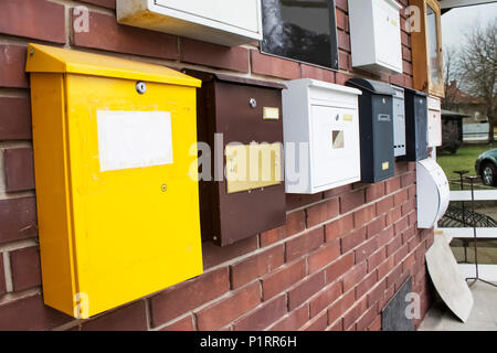 Viele bunte Briefkästen auf dem braunen Wand | leer | voll | Brick Stockfoto