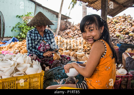 Mädchen und Frau an eine Kokosnuss Verarbeitung Familienunternehmen im Mekong Delta, Ben Tre, Vietnam Stockfoto