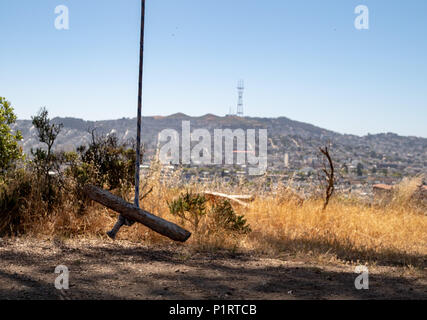 Eine einfache Planke schwingen hängen am Baum mit Sutro Tower und Twin Peaks sitzen in der Ferne Stockfoto