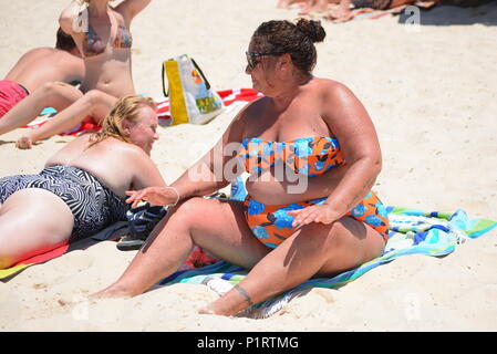 Ein übergewichtiger, plus größe Frau genießen, Sonnenbaden am Strand. Stockfoto