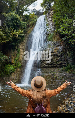 Frau in Hat sich Ihre Hand in der Nähe des Wasserfalls im Botanischen Garten in Tiflis, Georgien Stockfoto