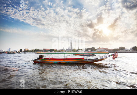 Traditionelle Thai Long tail Boot im Chao Phraya River in der Nähe von Wat Arun bei Sonnenuntergang in Bangkok, Thailand Stockfoto