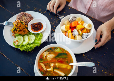 Traditionelle thailändische sauer Suppe Tom Yam in vegetarischen Variation, Curry Reis und Obst Salat in veganes Restaurant in Bangkok. Stockfoto