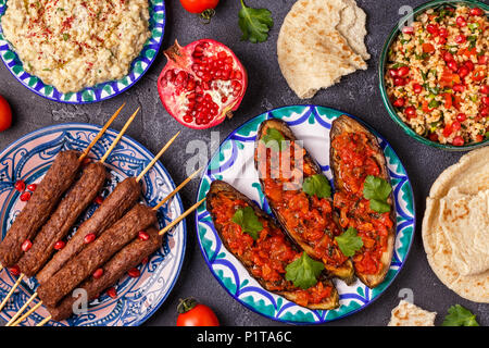Klassische Kebabs, tabbouleh Salat, Baba ganush und gebackene Auberginen mit Soße. Traditionelle orientalische oder arabische Gericht. Ansicht von oben. Stockfoto