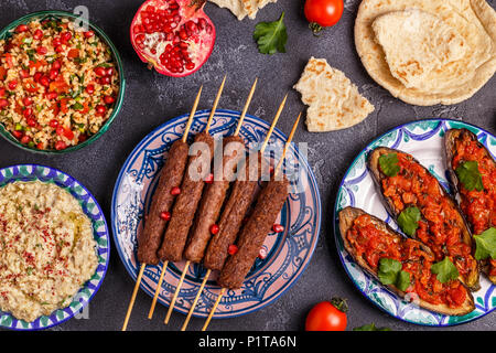 Klassische Kebabs, tabbouleh Salat, Baba ganush und gebackene Auberginen mit Soße. Traditionelle orientalische oder arabische Gericht. Ansicht von oben. Stockfoto