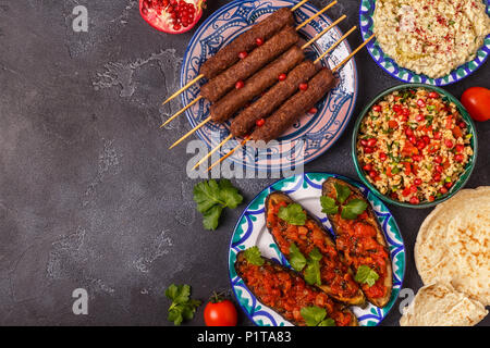 Klassische Kebabs, tabbouleh Salat, Baba ganush und gebackene Auberginen mit Soße. Traditionelle orientalische oder arabische Gericht. Ansicht von oben. Stockfoto