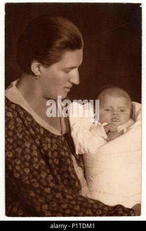 Die tschechoslowakische Republik - circa 1930s: Vintage Foto zeigt Frau mit Baby (Neugeborene) in Windeln. Retro black & white Studio. Stockfoto