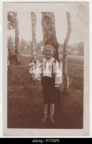 Die tschechoslowakische Republik - ca. 1940 s: Vintage Foto zeigt einen kleinen Jungen vor der Tür. Birken sind im Hintergrund. Retro Schwarz/Weiß-Fotografie. Stockfoto