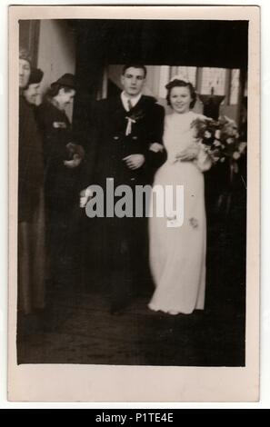 Prag, der Tschechoslowakischen Republik - 9. MÄRZ 1940: Vintage Foto zeigt Jungvermählten. Hochzeit - Braut und Bräutigam gehen von Kirche/Dom. Retro schwarz-weiß Fotografie mit Sepia Effekt. Stockfoto