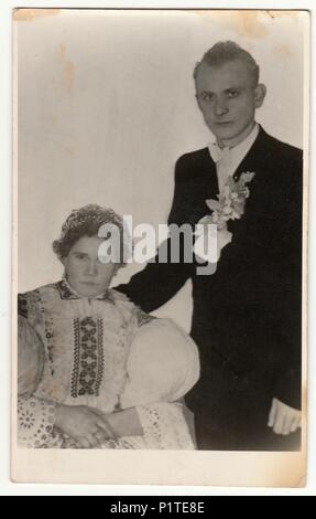 DOLNI VĚSTONICE, der Tschechoslowakischen Republik - ca. 1940 s: Vintage Foto zeigt Paar in einem Fotostudio. Frau trägt eine Tracht. Retro black & white Studio. Stockfoto