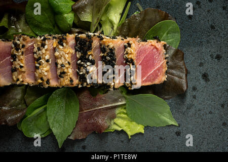 Gegrillter Thunfisch Steak in Scheiben geschnitten Sesam mit Salat und Wasabi Sauce Stockfoto