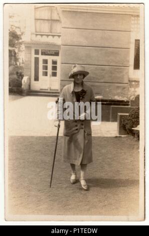 LUHACOVICE, der Tschechoslowakischen Republik - circa 1930s: Vintage Foto zeigt eine Frau mit einem Stock in der Spa Resort. Frau geht für einen Spaziergang. Retro schwarz & weiß phorography. Stockfoto