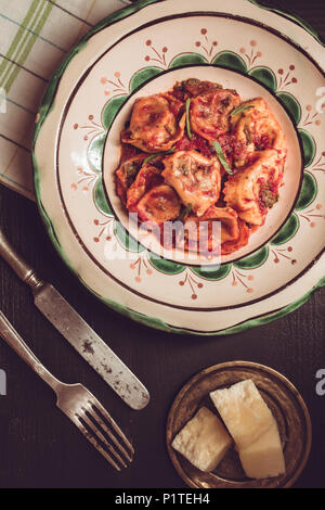 Italienisch Tortellini, Tomatensauce, Mozzarella und Basilikum auf Grüne rustikale Platte Stockfoto