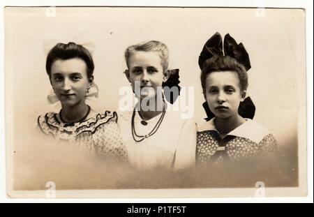 HAMBURG, DEUTSCHLAND - circa 1940s: Vintage Foto zeigt eine Gruppe von Mädchen wirft im Fotostudio. Mädchen trägt Haarband und einige von ihnen Halskette ((String) Perlen). Retro schwarz-weiß Fotografie mit Sepia Effekt. Stockfoto