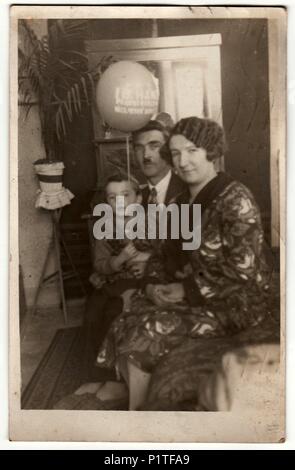 PRAHA (Prag), der Tschechoslowakischen Republik - 15. MÄRZ 1931: Vintage Foto zeigt Familie im Wohnzimmer. Junge hält Air-ball (Aufblasbare Kugel). Retro Schwarz/Weiß-Fotografie. Stockfoto